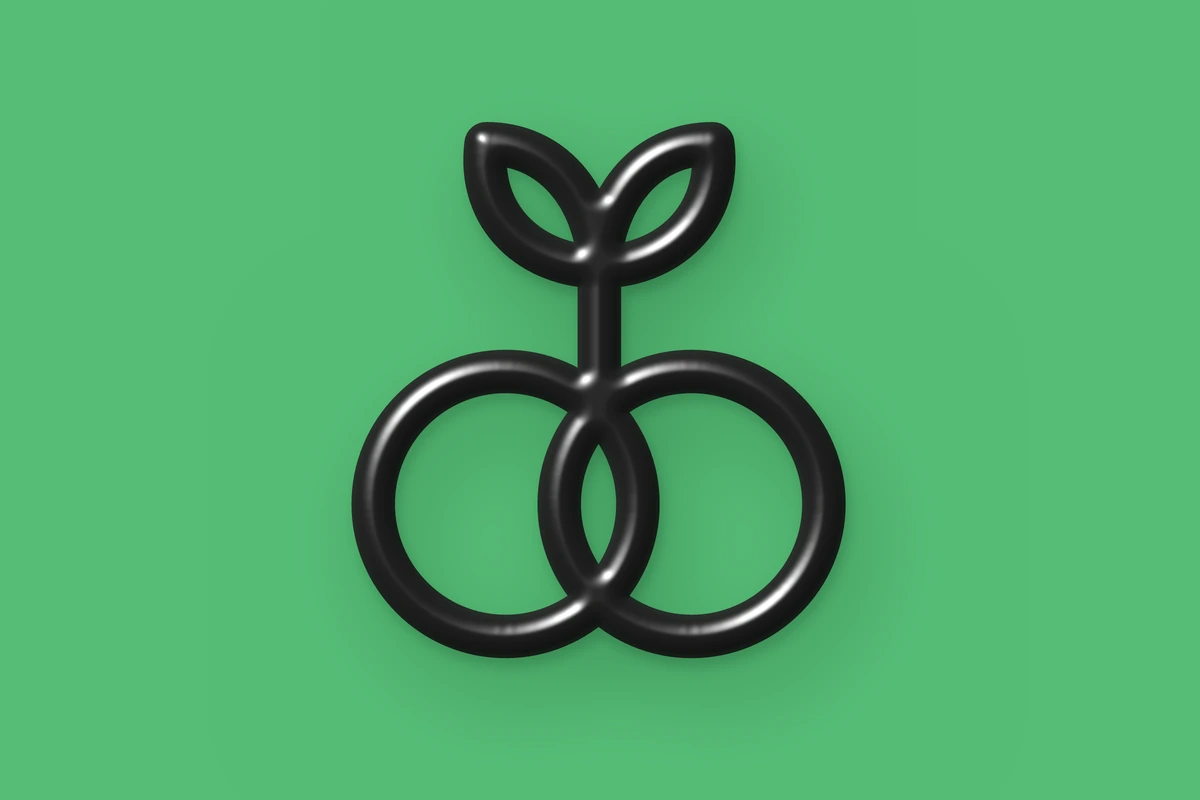 The vegansexual symbol, two interlocking circles beneath a single sprout, as a glossy black 3D object on green